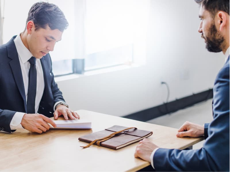 two men in suits at desk
